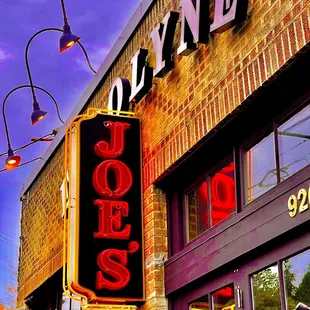 a neon sign on a brick building