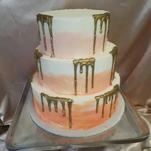 a three tiered cake with drips