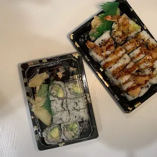 two trays of sushi on a table