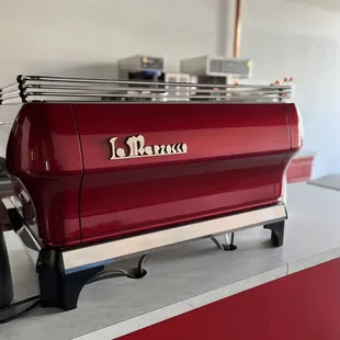 a red espressor machine in a kitchen