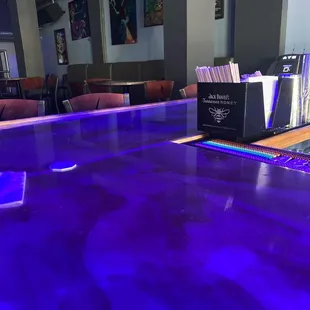 a purple bar with a neon blue counter top