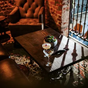 a glass of wine and a bowl of fruit on a table