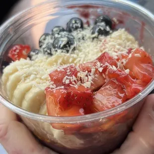 a person holding a bowl of fruit