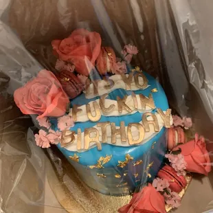 a blue birthday cake with pink roses