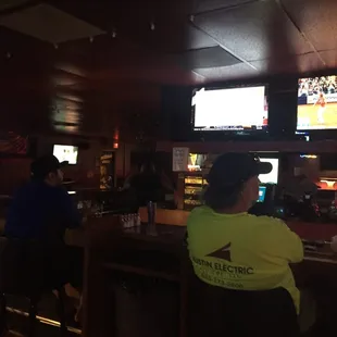 people sitting at the bar watching the game