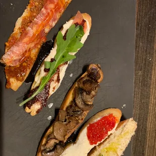 three hotdogs with bacon, mushrooms, and tomatoes