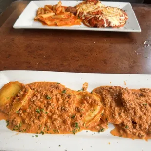 Dinner plate of Ravioli in a beef cream sauce and Chicken Parmesan.