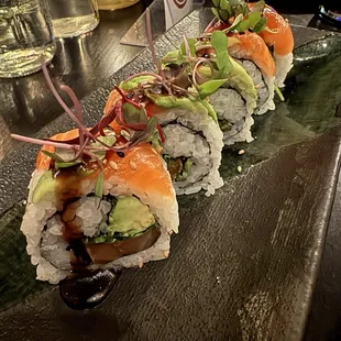 a sushi roll with salmon, avocado, and lettuce