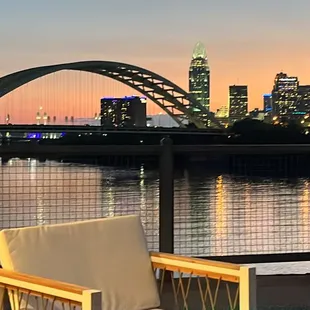 a woman sitting on a bench overlooking the city skyline