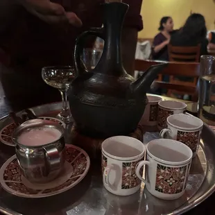 a tray of coffee cups and a teapot