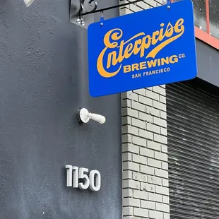a blue sign hanging from the side of a building