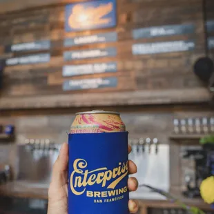 a person holding a can of beer