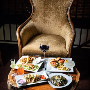 a table with plates of food and a glass of wine