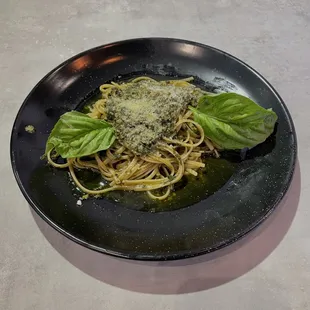 a plate of spaghetti with basil leaves