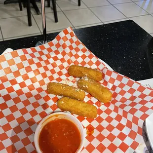 a basket of churros and dipping sauce