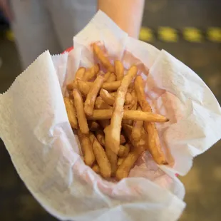 a person holding a basket of french fries