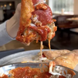 a slice of pizza being lifted by a fork