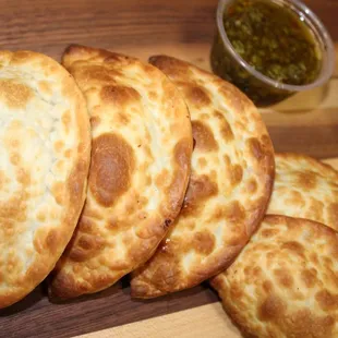 a pile of empanadas on a cutting board