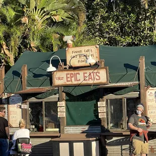 people standing in front of a food stand