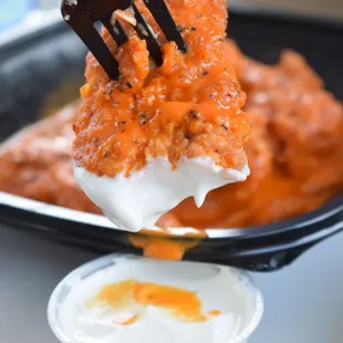 a person holding a fork over a plate of food