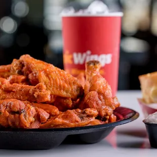 a bowl of wings and a sandwich