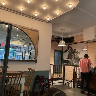 a woman standing at a counter in a restaurant