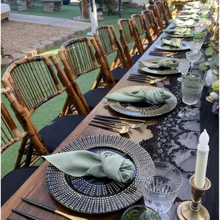 Bamboo chairs with black/gold utensils. Paired with black and gold glass chargers.