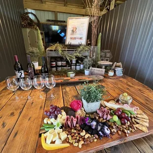 a wooden table with wine glasses and a platter of food