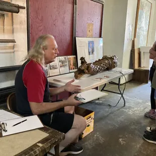John Schlick explaining his broken Dragon sculpture to get letters for the City of Sea to receive grant money.
