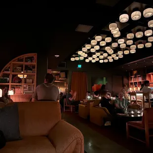 people sitting at tables in a dimly lit room