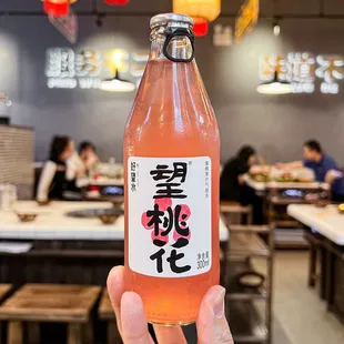 a person holding a bottle of hot pot