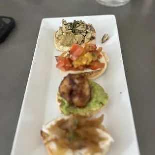 Crostini Flight:  Mushroom &amp; artichoke Blackened shrimp &amp; avocado Goat cheese &amp; caramelized onion Caprese Bruschetta smoked mozzarella