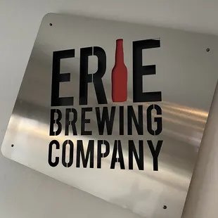a bottle of beer on a metal sign