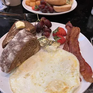Basic breakfast with 3 eggs, bacon, and rye. Across from that is a goat cheese mushroom scramble with a gluten free bun and tater tots.