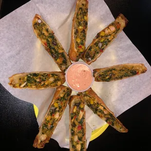 a plate of breadsticks with dipping sauce