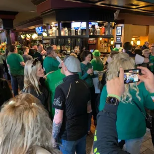 a crowd of people in green shirts