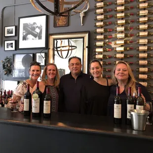 a group of people standing behind a bar