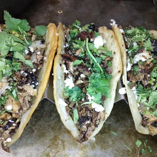 three tacos on a cutting board