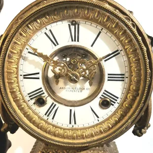 Closeup of Ansonia beveled glass clockface showing Louis XV hands and open Brocot escapement