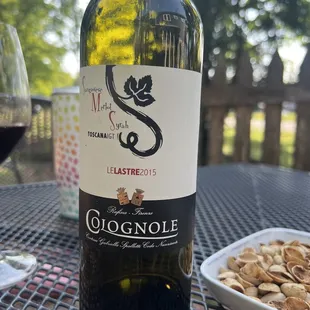 a glass of wine and a plate of nuts