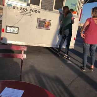 a group of people standing in front of a food truck