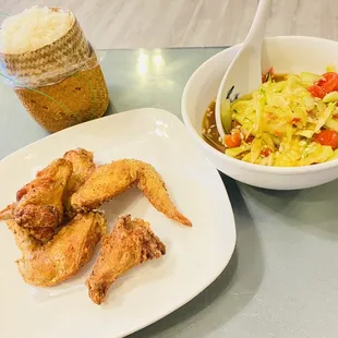 a plate of chicken wings and a bowl of salad