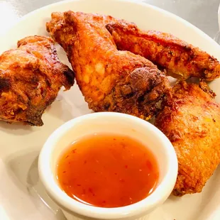 a plate of fried chicken wings with dipping sauce