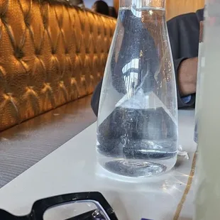 Dusty carafe of room temperature water with plastic cups....