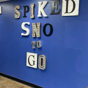 a blue wall with a sign that says i spiked sno to go