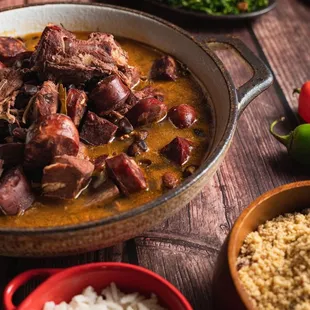 a bowl of stew and bowls of rice