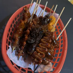 a basket of skewered food