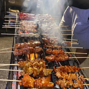 several skewered meats on a grill