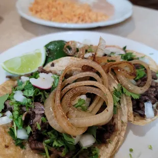 Steak tacos Mexican style with beans and rice.
