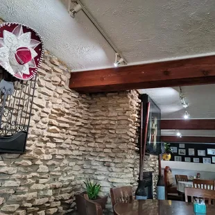 a dining room with a stone wall